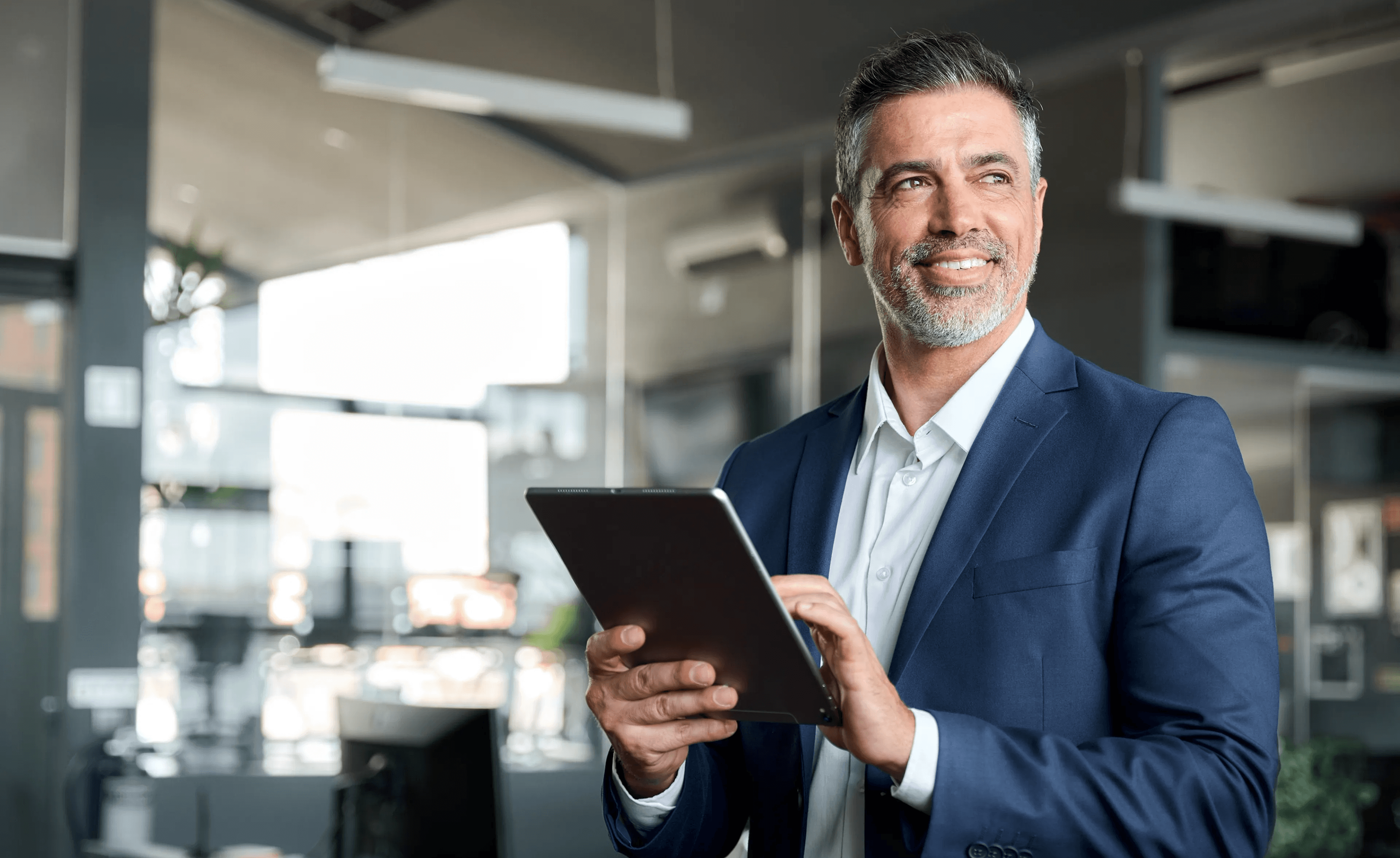 Tablet használó mosolygós üzletember.